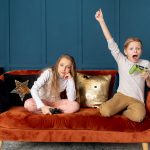 children playing video games on luxury velvet sofa